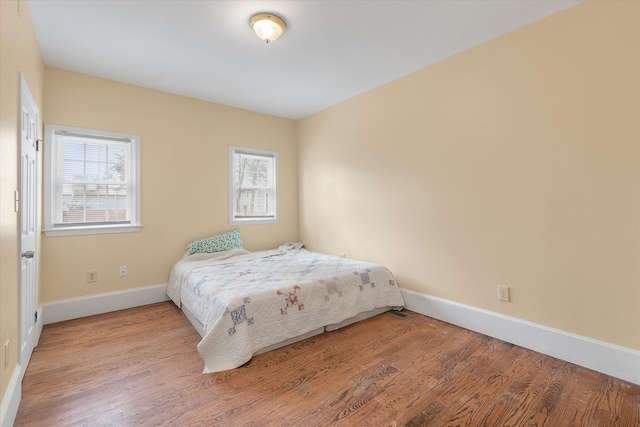 bedroom featuring hardwood / wood-style floors and multiple windows