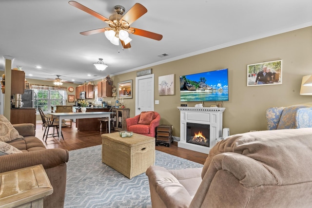 1583 Southwick Dr, Johns Island, SC 29455 - living area featuring a ceiling fan, crown molding, wood finished floors, a warm lit fireplace, and recessed lighting
