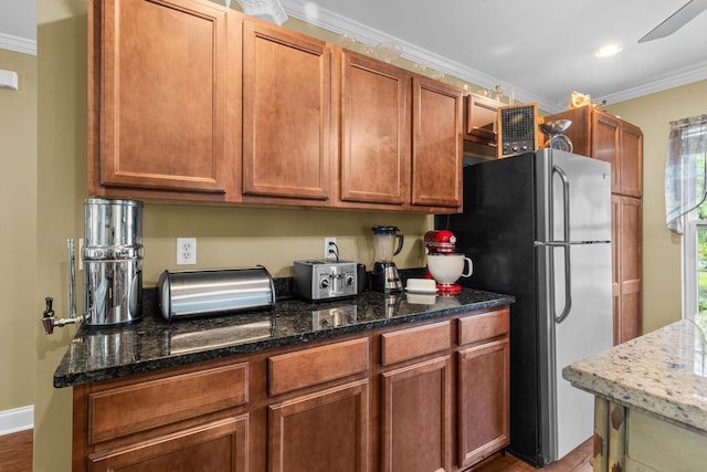 1583 Southwick Dr, Johns Island, SC 29455 - kitchen with freestanding refrigerator, crown molding, dark wood-style flooring, and dark stone countertops