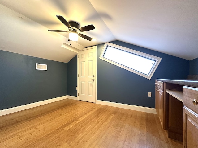 additional living space featuring vaulted ceiling, light hardwood / wood-style floors, and ceiling fan