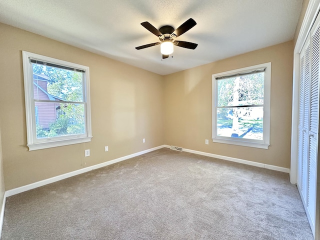 unfurnished bedroom featuring a closet, carpet floors, and multiple windows