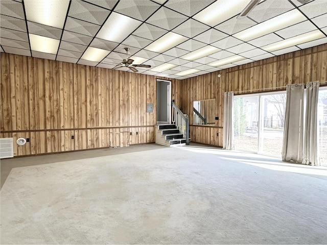 interior space with a paneled ceiling and wood walls