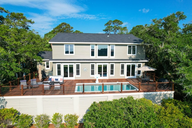 rear view of property with a swimming pool side deck and an outdoor hangout area