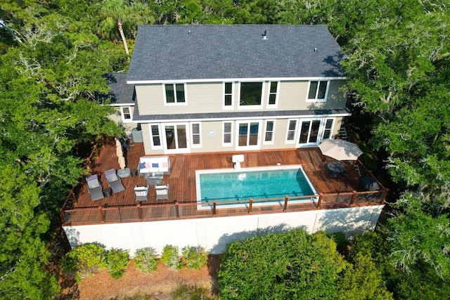 rear view of property featuring a pool side deck