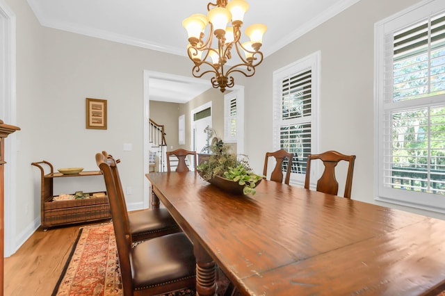 dining room with crown molding, an inviting chandelier, and light hardwood / wood-style floors