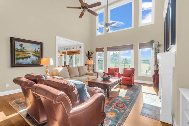 living room featuring wood-type flooring and ceiling fan with notable chandelier