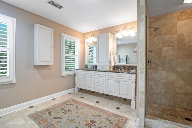 bathroom featuring vanity, a tile shower, and tile patterned floors