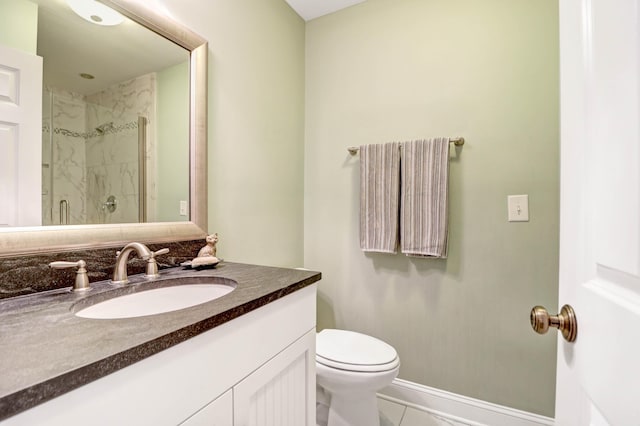 bathroom featuring vanity, a shower with shower door, and toilet