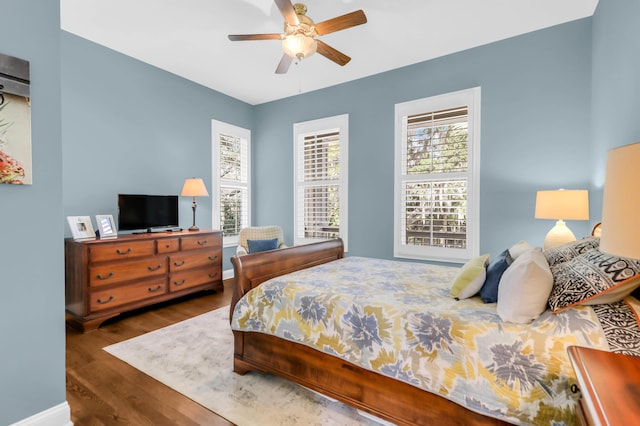 bedroom with dark hardwood / wood-style flooring and ceiling fan