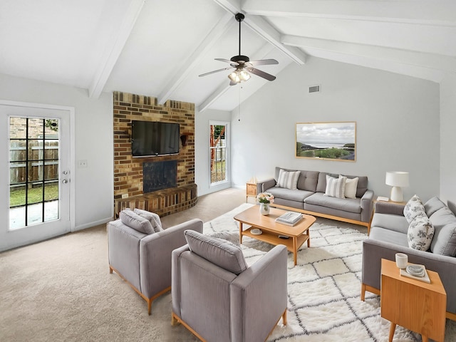 living room with light carpet, lofted ceiling with beams, a brick fireplace, and ceiling fan