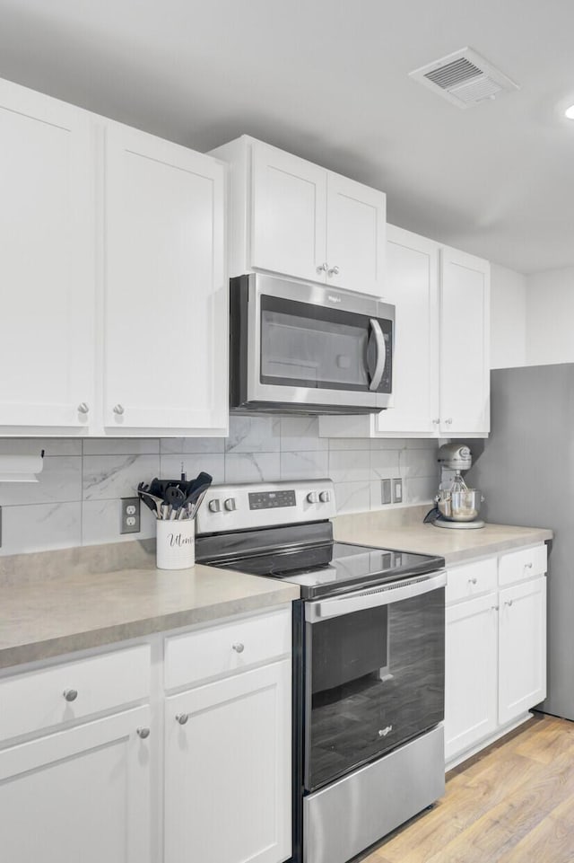 127 Rosefield Ct, Summerville, SC 29485 - kitchen with stainless steel appliances, backsplash, visible vents, and white cabinets