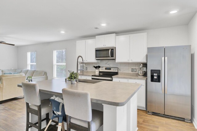 127 Rosefield Ct, Summerville, SC 29485 - kitchen with light wood finished floors, tasteful backsplash, open floor plan, light countertops, and stainless steel appliances
