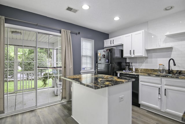 8096 Shadow Oak Dr, North Charleston, SC 29406 - kitchen featuring black appliances, white cabinets, decorative backsplash, a sink, and a center island