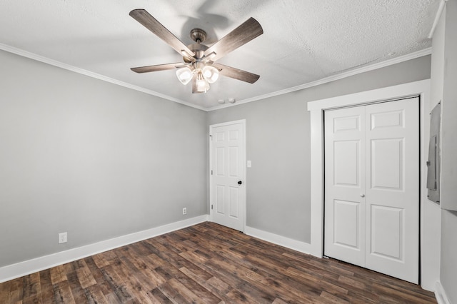 unfurnished bedroom with ceiling fan, dark hardwood / wood-style floors, crown molding, a textured ceiling, and a closet