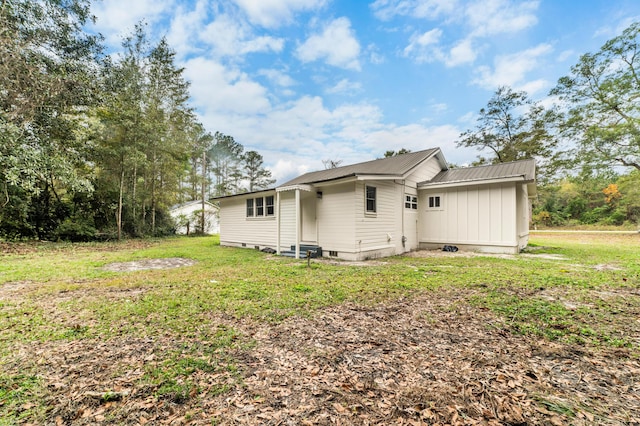 rear view of property with a yard