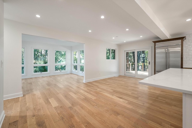 unfurnished living room featuring a healthy amount of sunlight and light hardwood / wood-style flooring