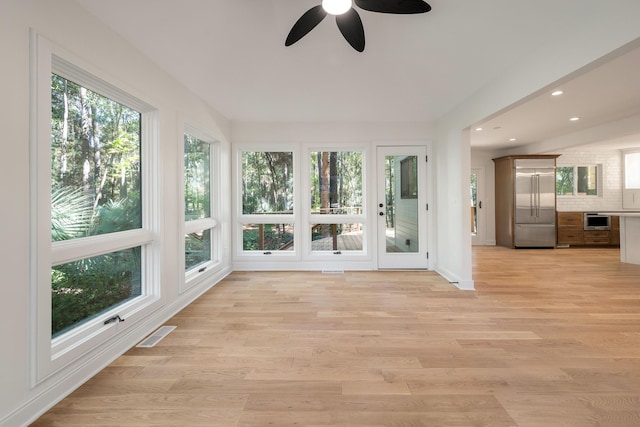 unfurnished sunroom featuring plenty of natural light and ceiling fan