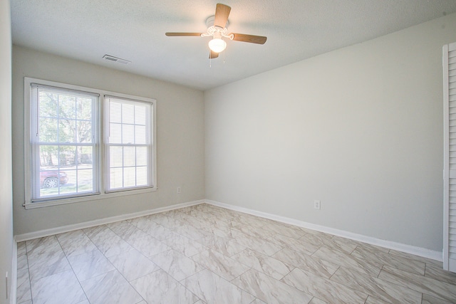 spare room featuring ceiling fan and a textured ceiling