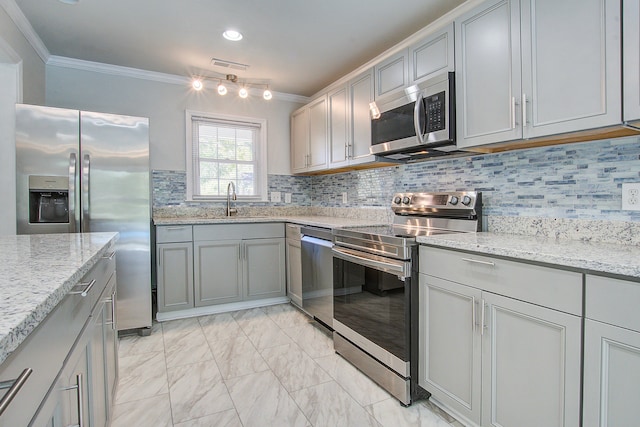 kitchen featuring light stone countertops, stainless steel appliances, crown molding, and gray cabinetry