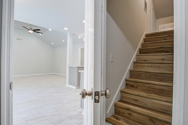 stairs with lofted ceiling and ceiling fan