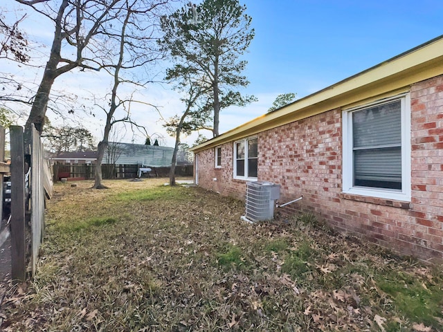 view of yard with central AC unit and fence