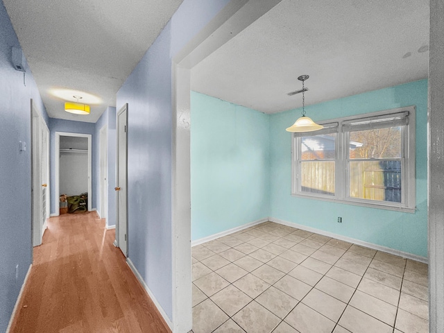 interior space featuring a textured ceiling, visible vents, and baseboards