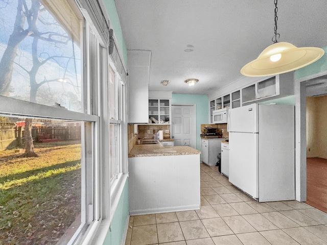 kitchen with white appliances, decorative backsplash, glass insert cabinets, white cabinetry, and light tile patterned flooring