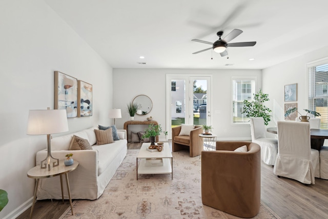 living room featuring ceiling fan and light hardwood / wood-style flooring