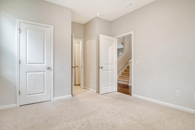 unfurnished bedroom featuring light carpet