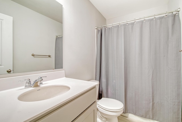 bathroom featuring vanity, curtained shower, and toilet