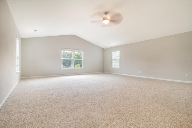 spare room with ceiling fan, light carpet, and vaulted ceiling