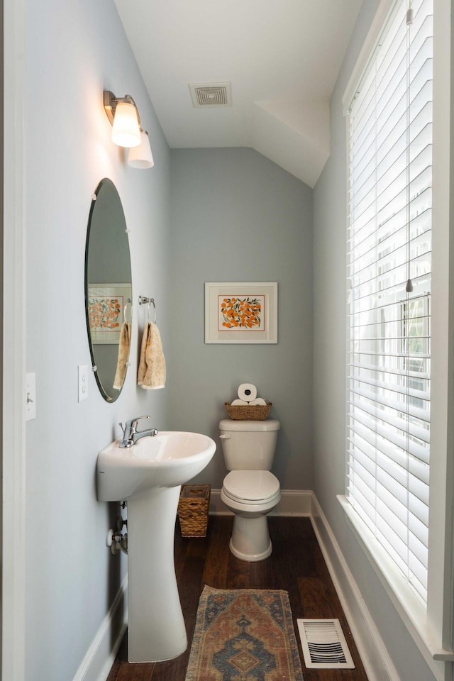 bathroom with toilet, wood finished floors, lofted ceiling, and baseboards