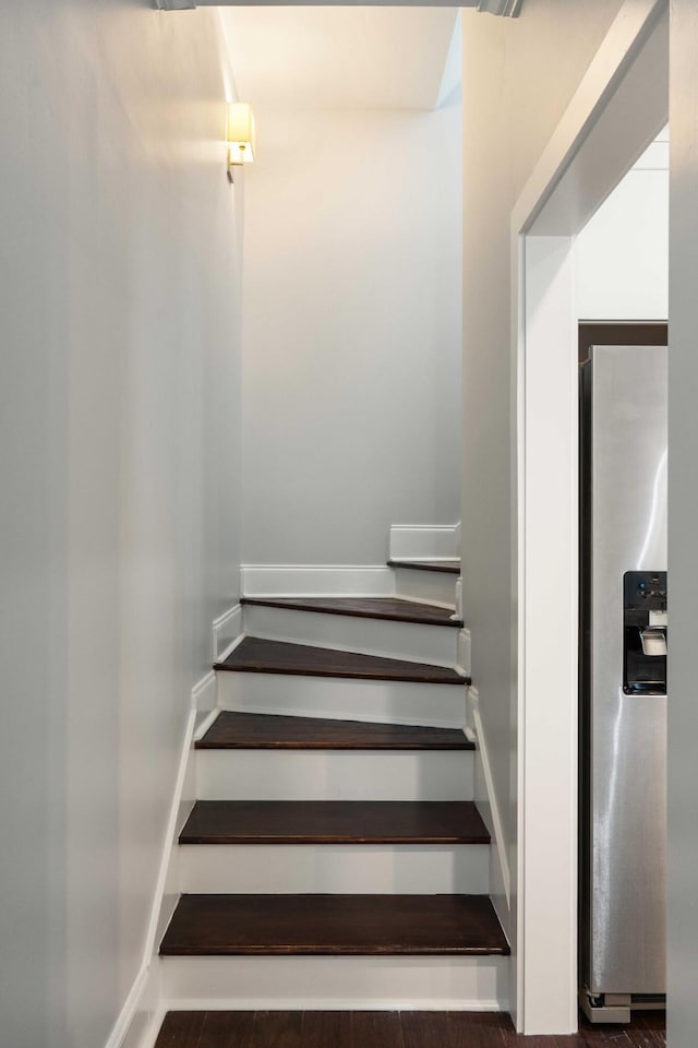 staircase with wood finished floors and baseboards
