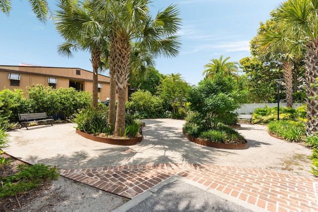 surrounding community featuring fence and decorative driveway
