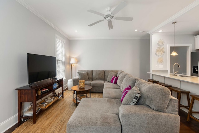 living room featuring light wood finished floors, recessed lighting, baseboards, ceiling fan, and crown molding