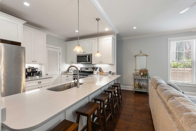 kitchen featuring stainless steel appliances, a sink, dark wood-style flooring, a breakfast bar area, and recessed lighting