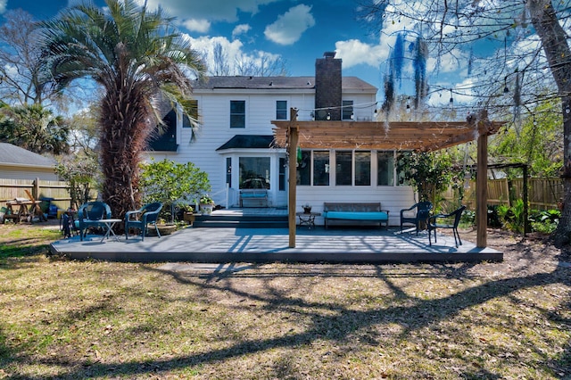 back of house with a chimney, a pergola, a deck, and fence