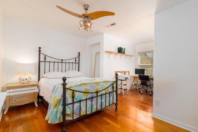 bedroom featuring visible vents, wood-type flooring, baseboards, and a ceiling fan