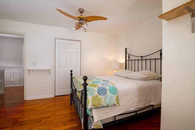 bedroom featuring ceiling fan, a closet, baseboards, and wood finished floors