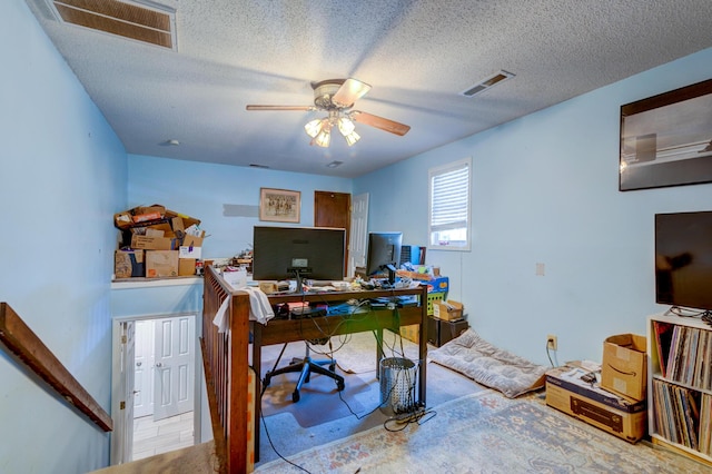 home office featuring a ceiling fan, visible vents, and a textured ceiling