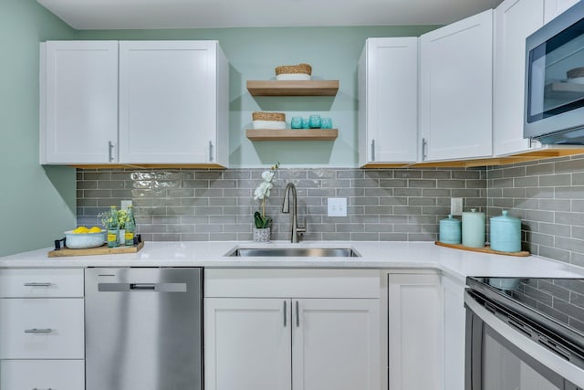 kitchen with backsplash, sink, white cabinets, and stainless steel appliances