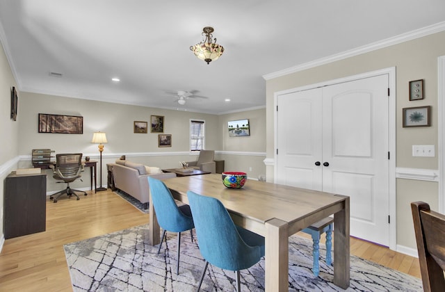 dining area with visible vents, crown molding, light wood-style flooring, and ceiling fan