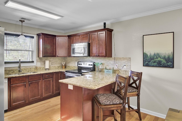 kitchen with light wood finished floors, tasteful backsplash, a peninsula, stainless steel appliances, and a sink