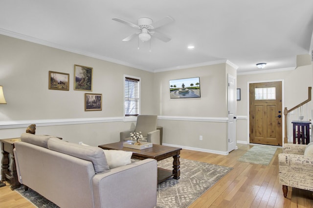 living room with light wood-style floors, a wealth of natural light, crown molding, and baseboards