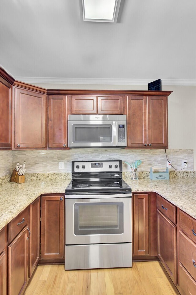 kitchen featuring light wood-type flooring, tasteful backsplash, ornamental molding, and stainless steel appliances