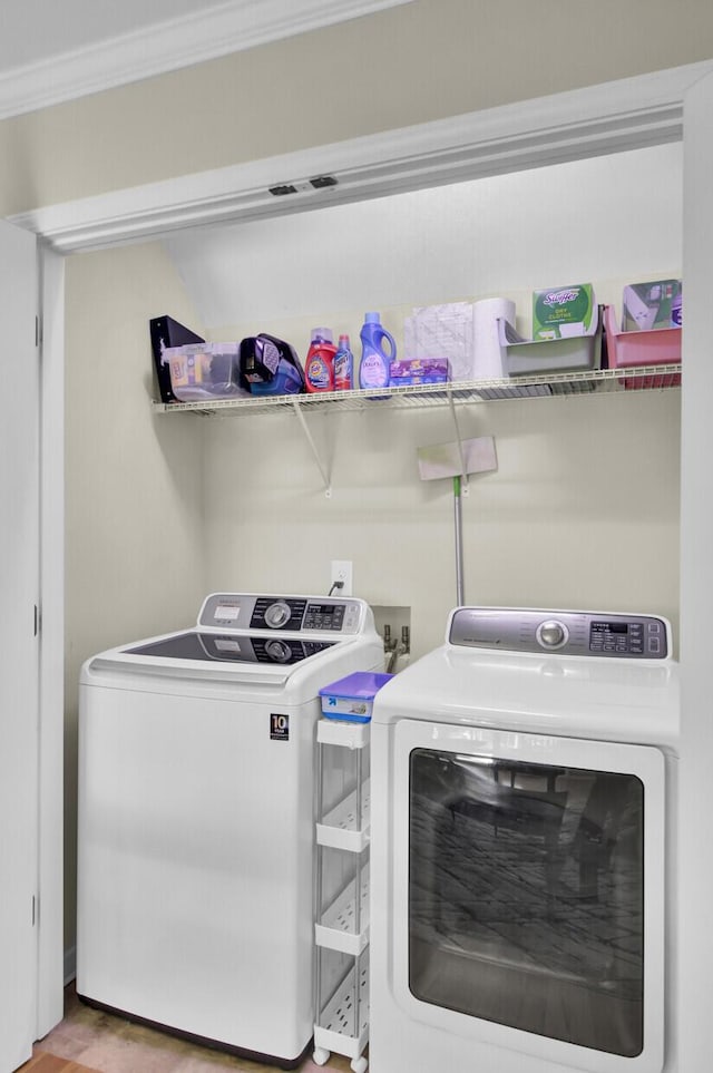 washroom with ornamental molding, laundry area, and separate washer and dryer