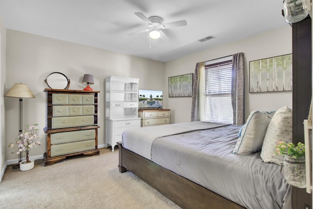 bedroom with light carpet, ceiling fan, visible vents, and baseboards