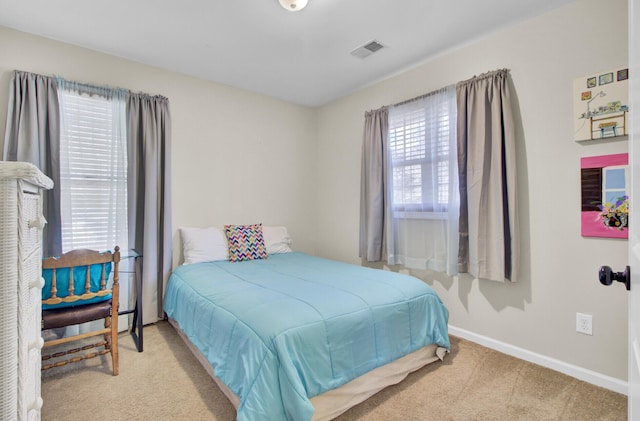 carpeted bedroom with visible vents and baseboards