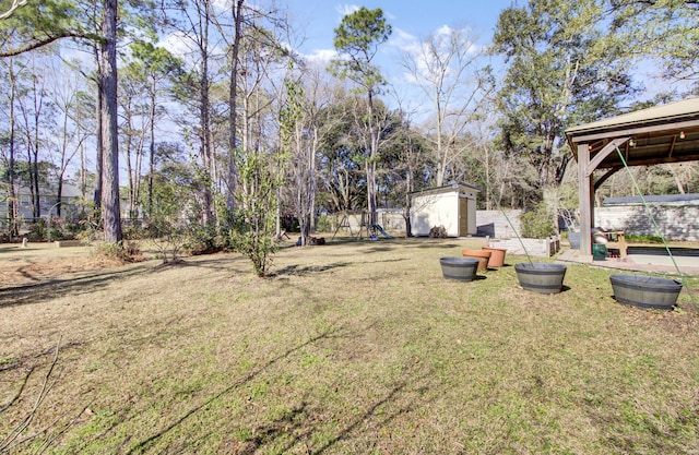 view of yard with a gazebo, a storage unit, a playground, and an outdoor structure