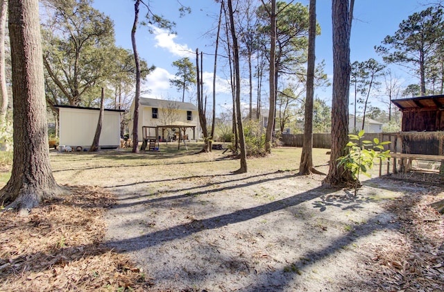 view of yard featuring fence and an outbuilding